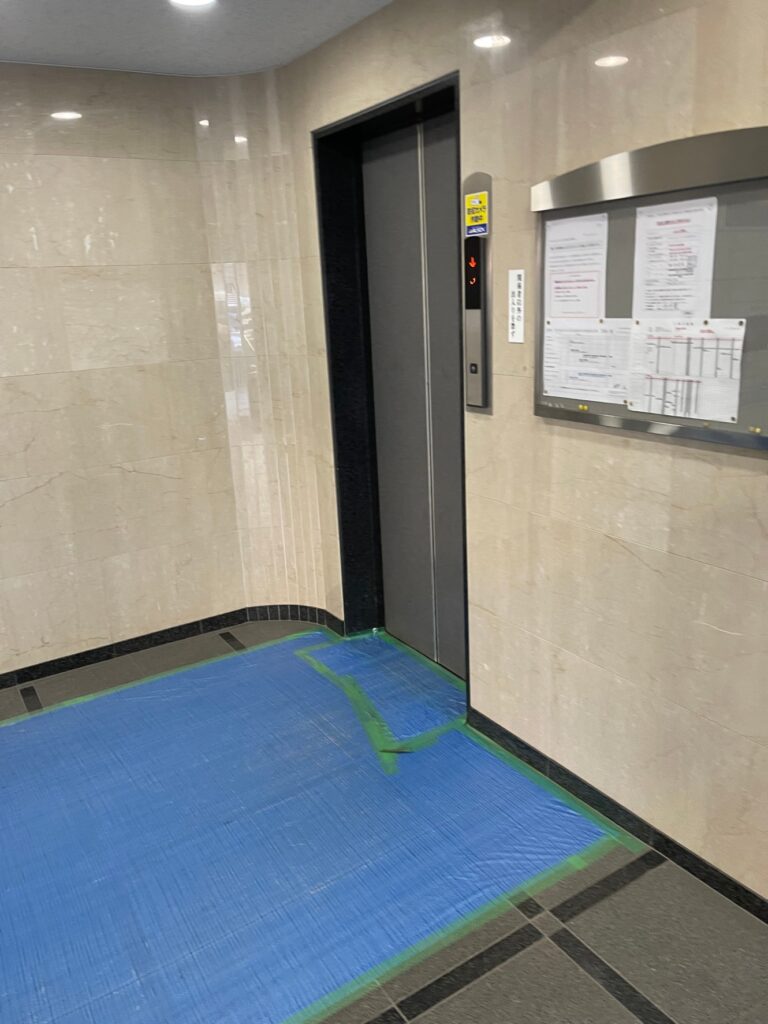 搬出の前に養生材を敷いたマンションのエレベーター前