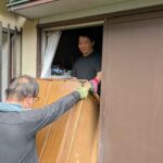 和室の窓から屋外へ家具を受け渡している様子