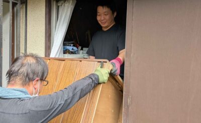 和室の窓から屋外へ家具を受け渡している様子