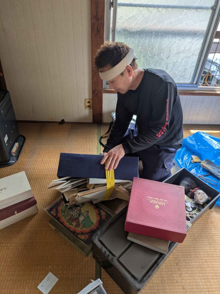 押入れから出した小物を箱ごとに仕分けている様子