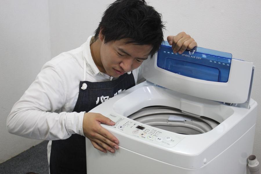 洗濯機を確認する店舗スタッフ
