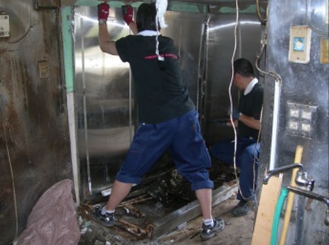 店舗をスケルトン状態にするため解体作業をしている作業員
