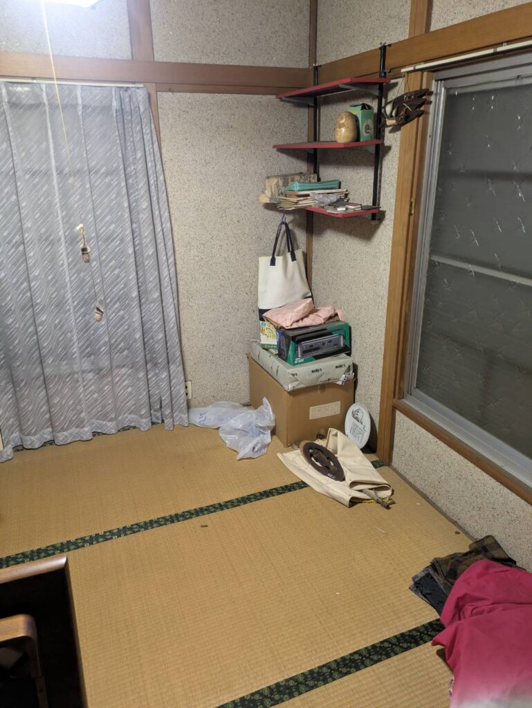 作業前の和室。壁の棚や紙袋、段ボールなどの小物が残っている