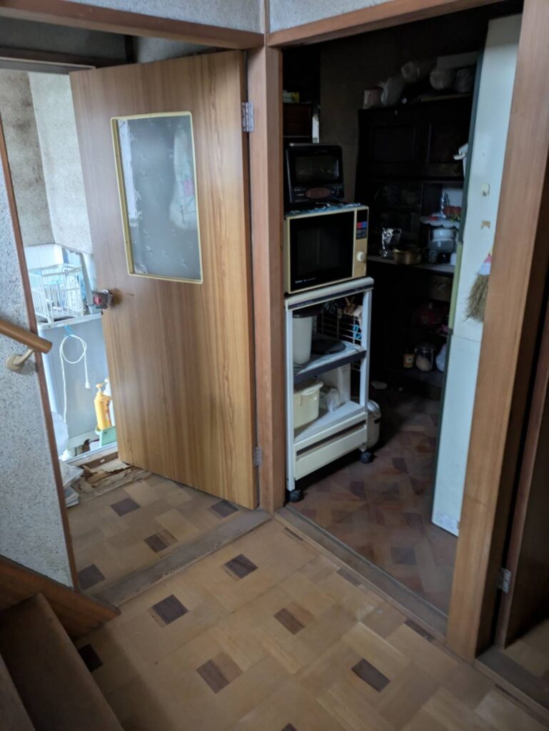 作業前の廊下。台所の入口に電子レンジ台や食器棚が残っている