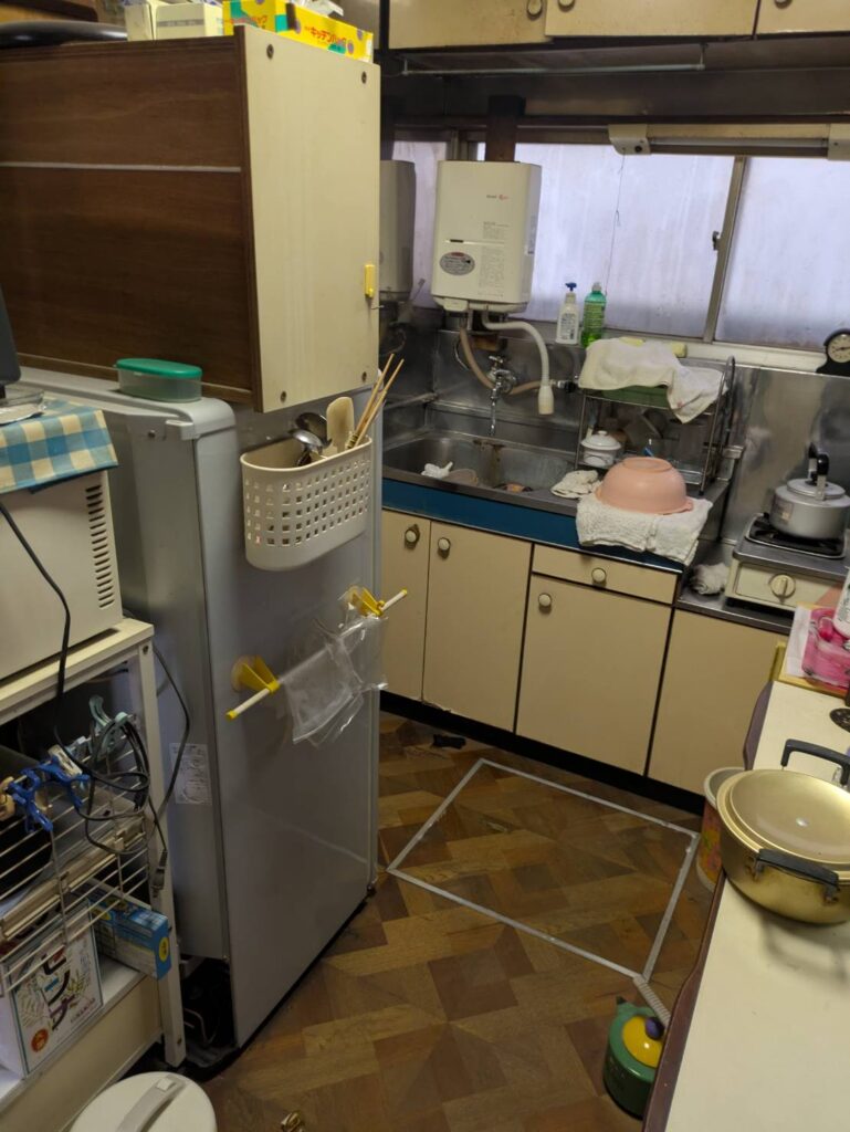 作業前の台所。冷蔵庫や調理器具、食器が残っている