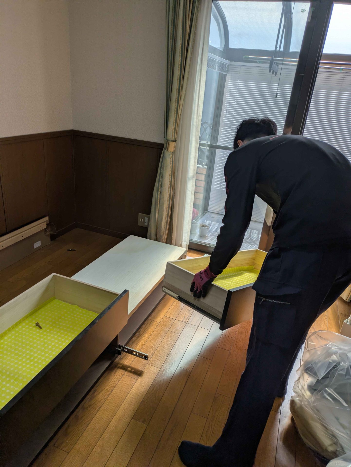 朝霞市本町の戸建てで収納ベッドの引き出しを外す当社スタッフ