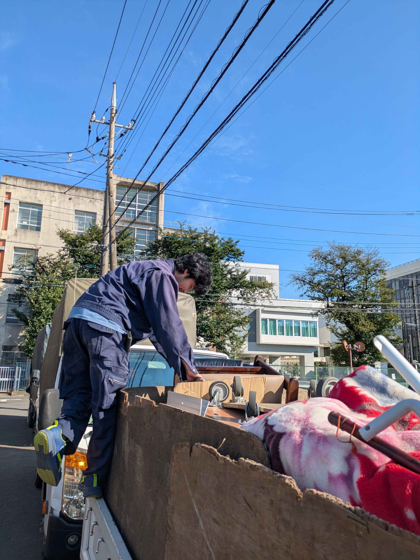 荷台の荷物が動かないように積み方を整える当社スタッフ