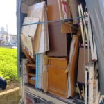 木製の家具と段ボールをベルトで固定したトラックの荷台
