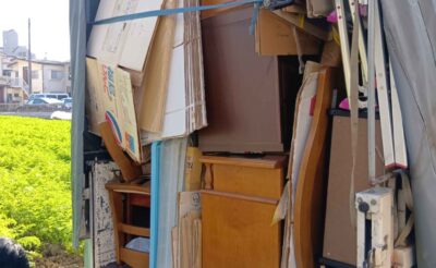 木製の家具と段ボールをベルトで固定したトラックの荷台
