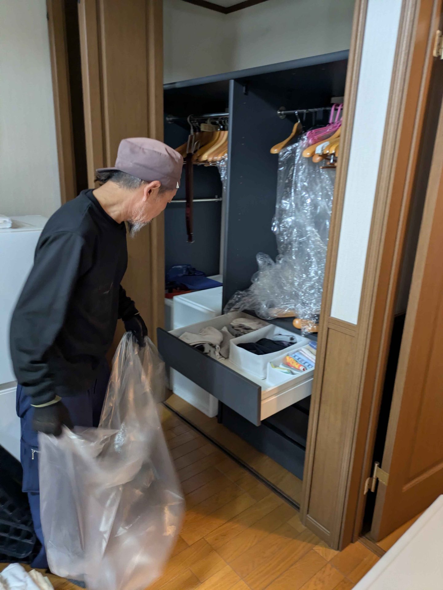 クローゼットの中身を透明の袋に詰める作業