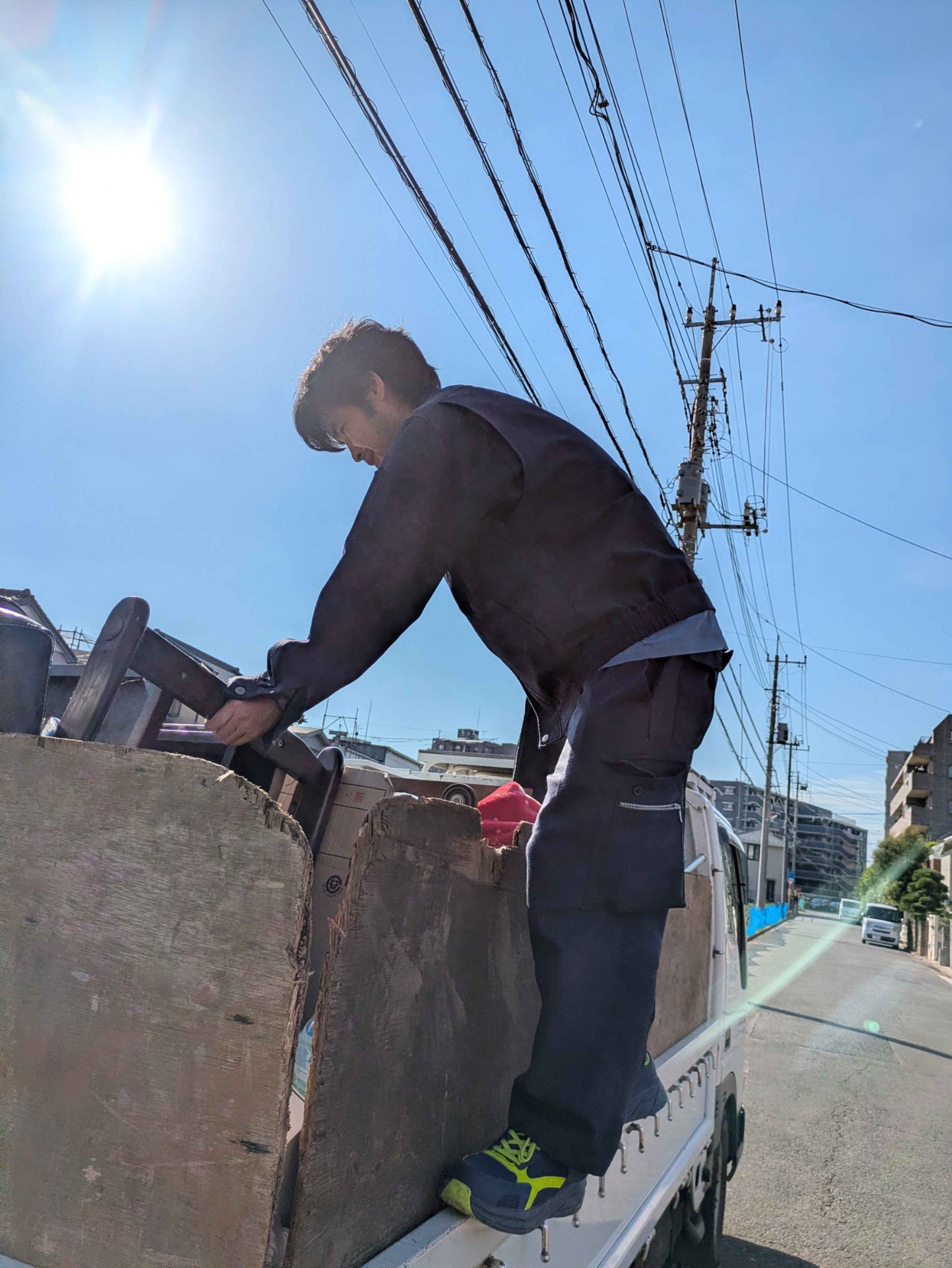 トラックの荷台に椅子などの家具を積み込む当社スタッフ