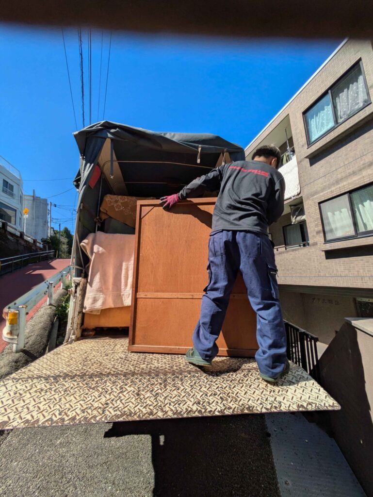 木製の家具をトラックの荷台に積み込む当社スタッフ
