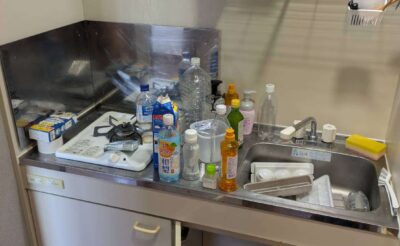 回収前のキッチン。シンク周りにボトル類や洗剤などの小物が残った状態