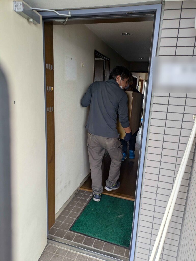 玄関から家具を運び出す当社スタッフ(表札はぼかしています)
