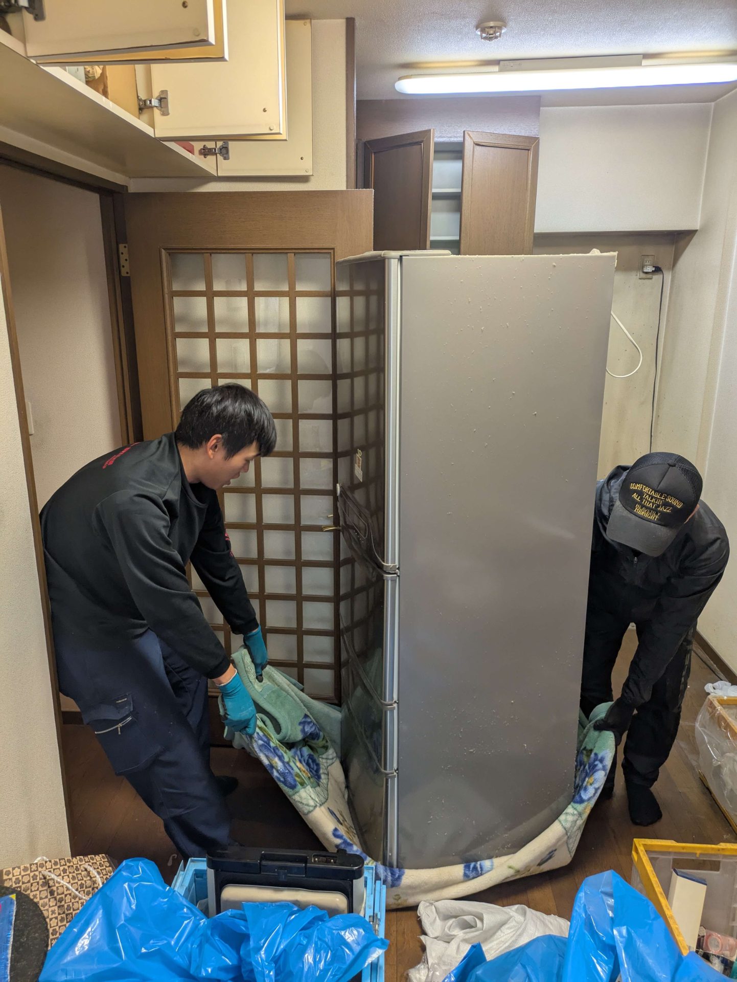 キッチンで冷蔵庫の下に毛布を敷いて動かす準備