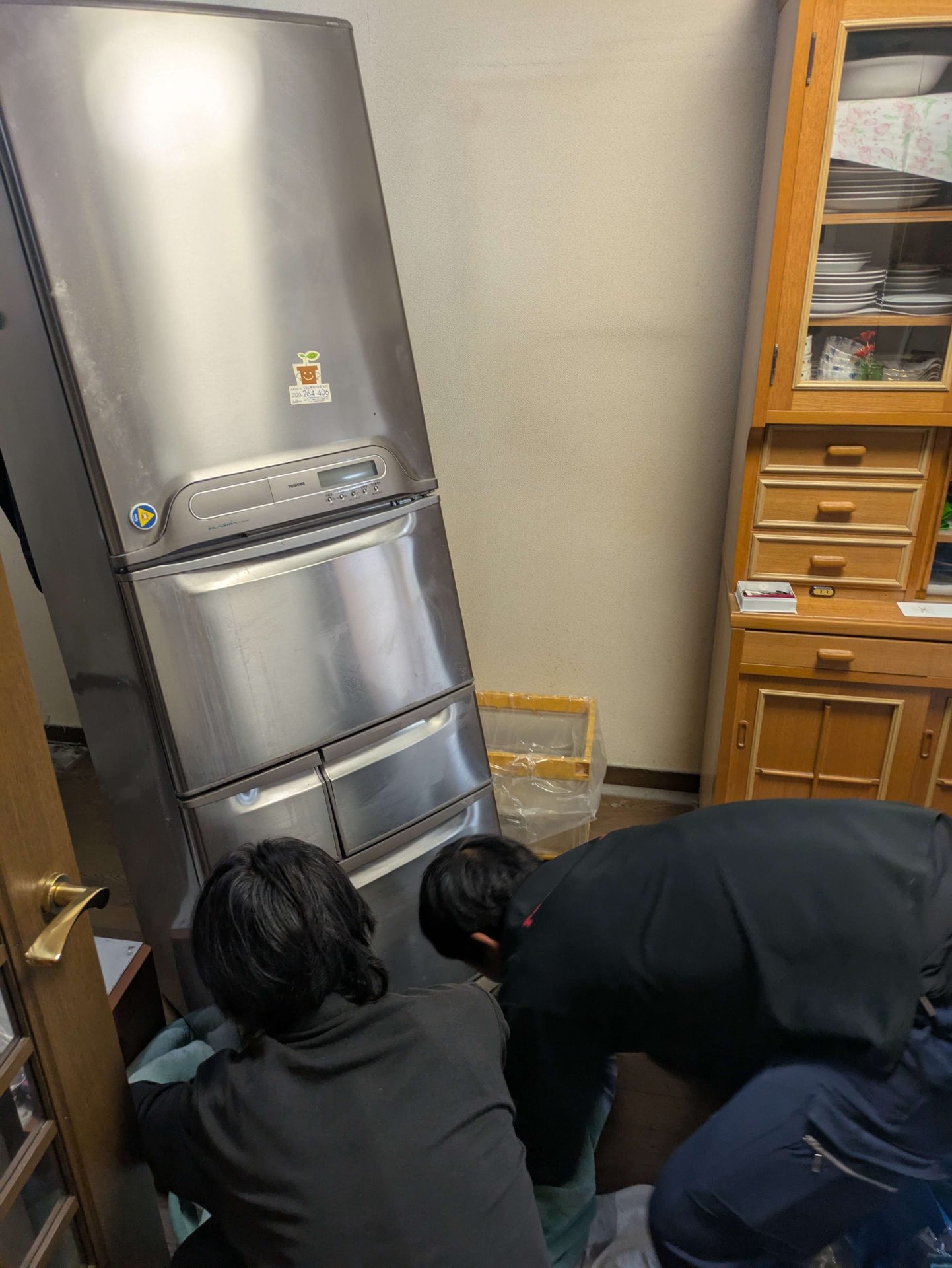 2人で冷蔵庫を手前に起こして搬出の向きを決める