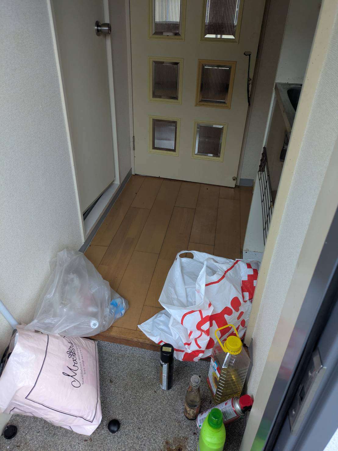 回収前の玄関に集められたレジ袋入りの生活用品