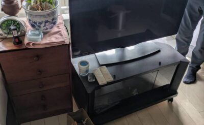 回収前の洋室。テレビ・テレビ台・チェスト・観葉植物が残された状態