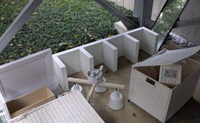 作業前:建物脇の共用スペースに置かれた収納かごや棚板(港区白金台)