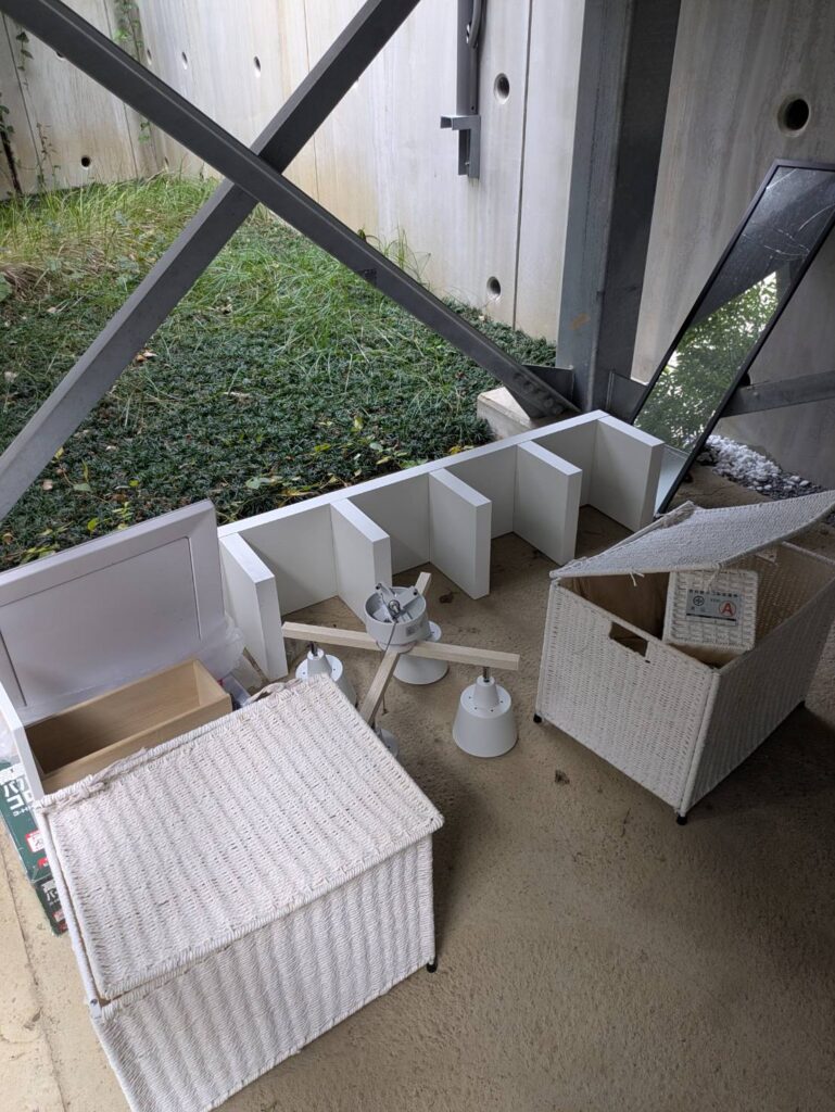 作業前：建物脇の共用スペースに置かれた収納かごや棚板（港区白金台）