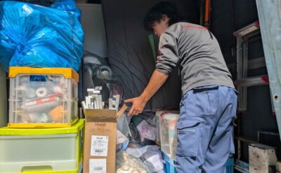 衣装ケースやコンテナ、ゴミ袋をトラックの荷台に積み上げる当社スタッフ