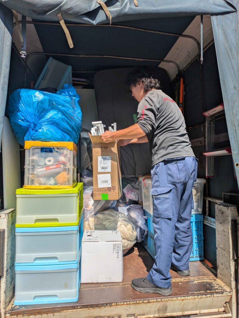 荷台のすき間に段ボールを積み込み、荷が動かないように整える当社スタッフ