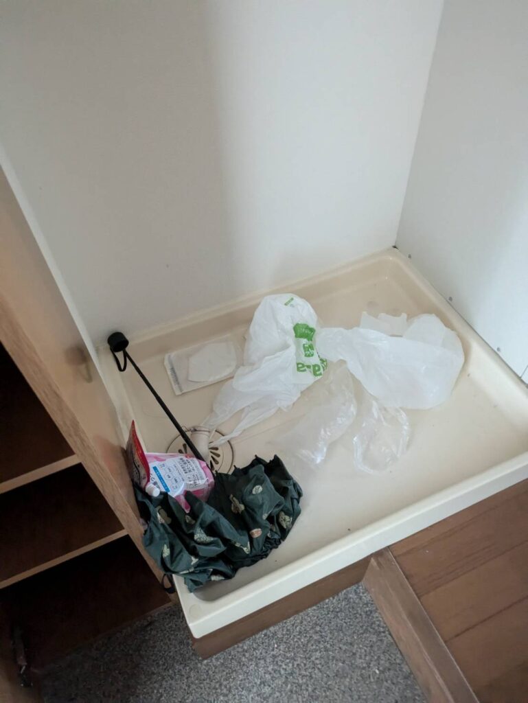 作業前：洗濯機置き場に残された袋や傘