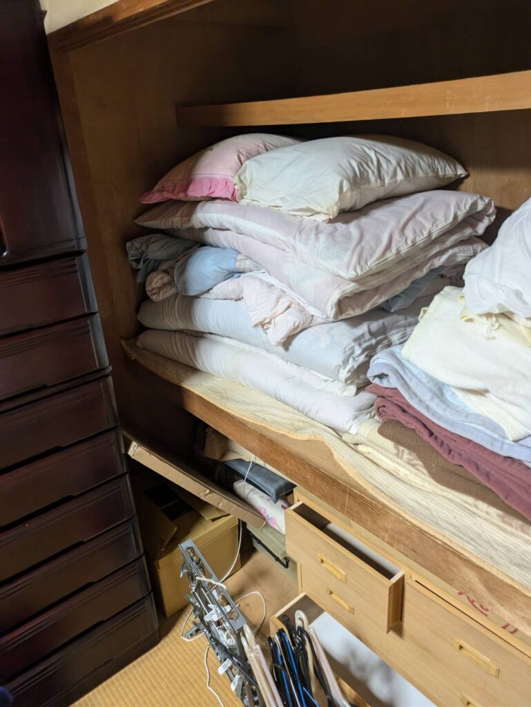 作業前:押し入れに積まれた布団と整理棚