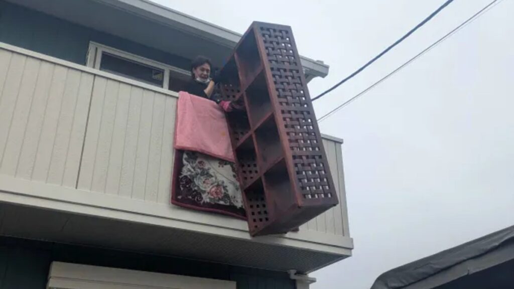 2階ベランダから大型の家具を吊り下げて搬出する当社スタッフ