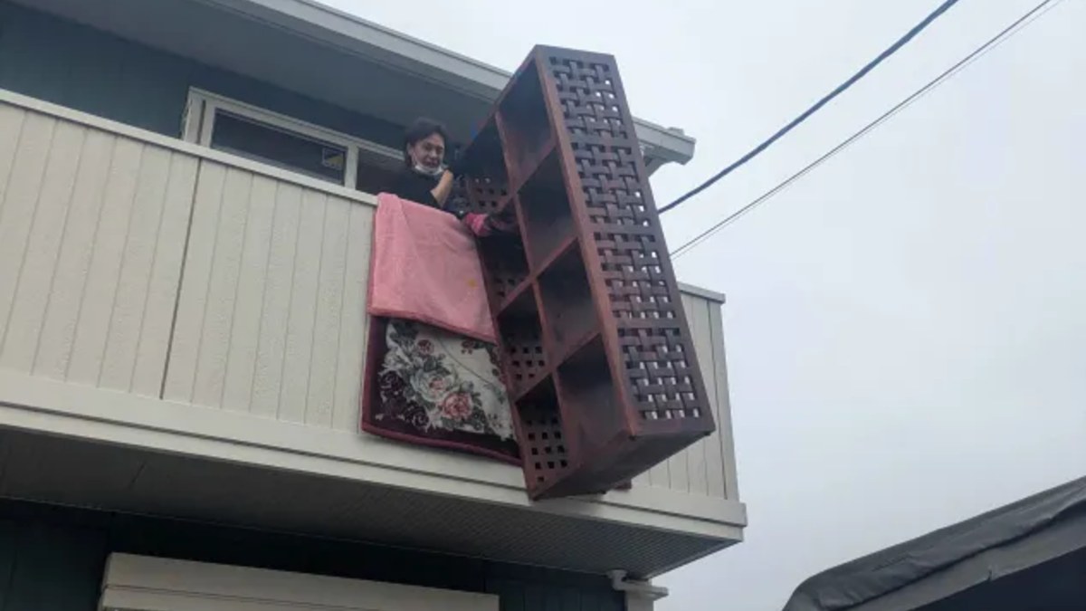 2階ベランダから大型の家具を吊り下げて搬出する当社スタッフ