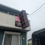 2階ベランダから大型タンスを吊り下げて搬出する当社スタッフ