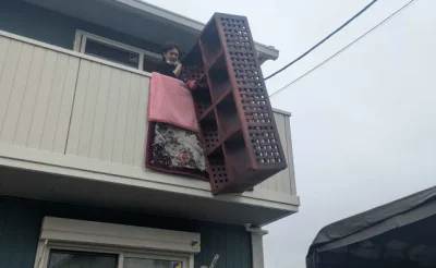 2階ベランダから大型タンスを吊り下げて搬出する当社スタッフ