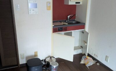 回収前の洋室。炊飯器やコード類、食品の袋が床に残った状態