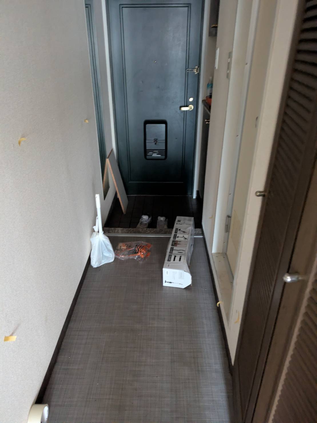 回収前の玄関。袋に入った生活ごみとトイレ洗浄用具が残った状態