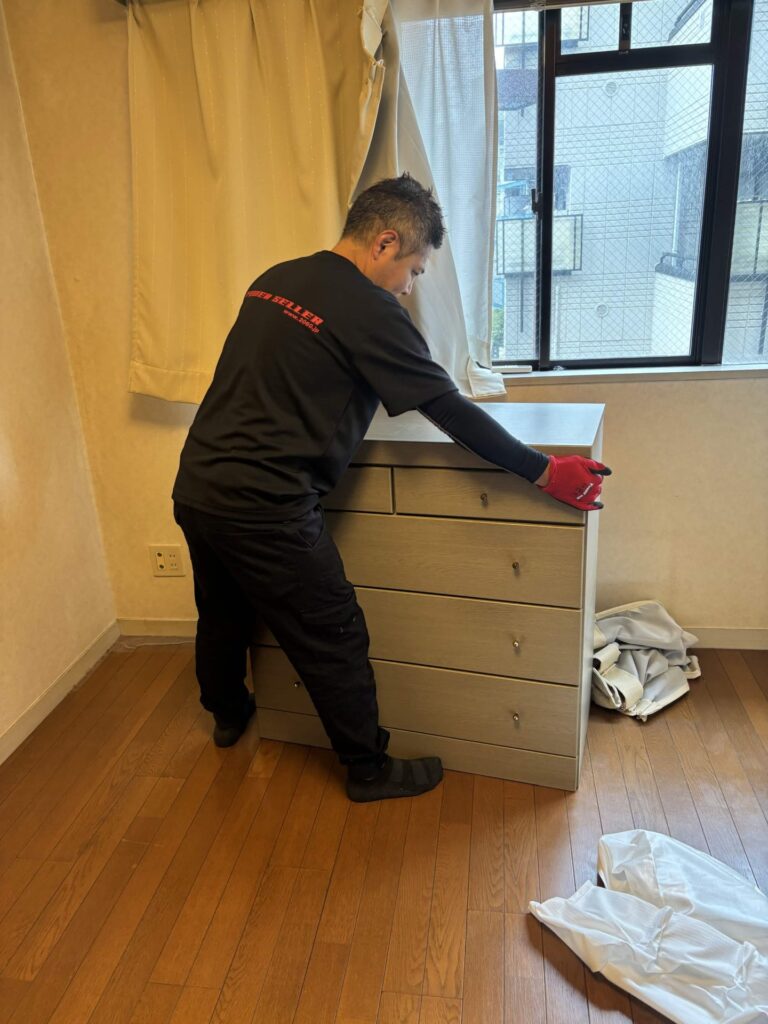 無人のお部屋で、チェストを運び出す前に中身を確認する当社スタッフ