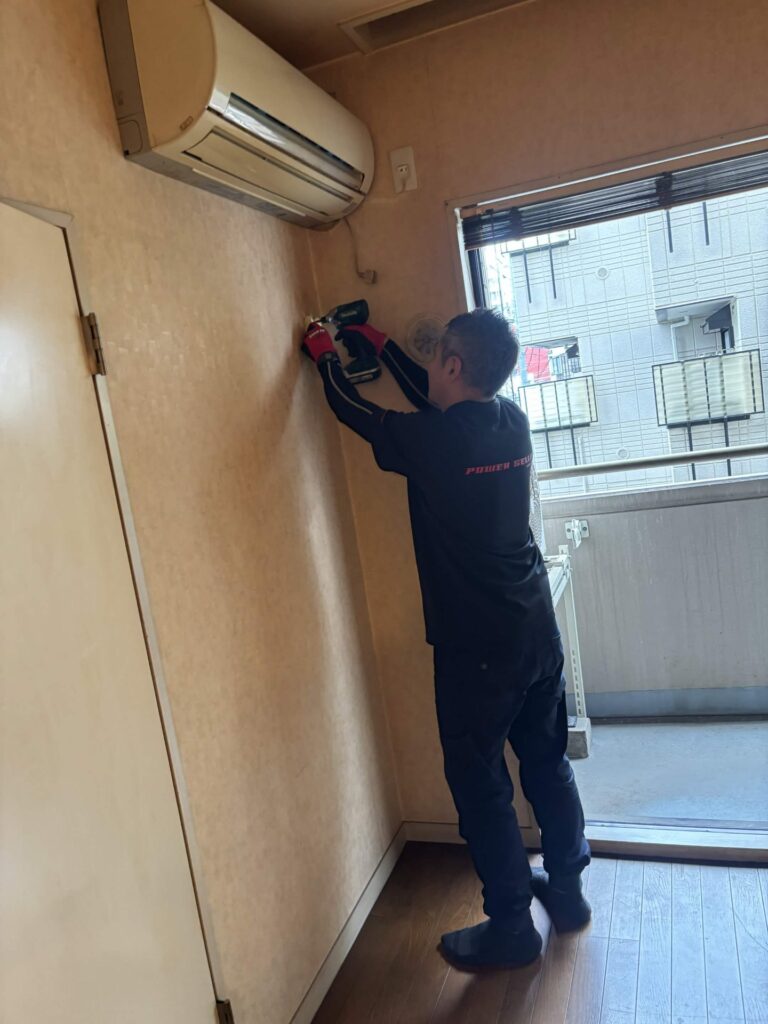 エアコンの室内機を取り外す当社スタッフ